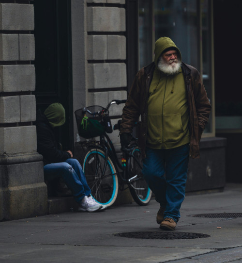 Homme sans-abri marchant dans la rue. Vieil homme avec une barbe blanche. Pauvreté, itinérance, itinérant. Human, people, homeless